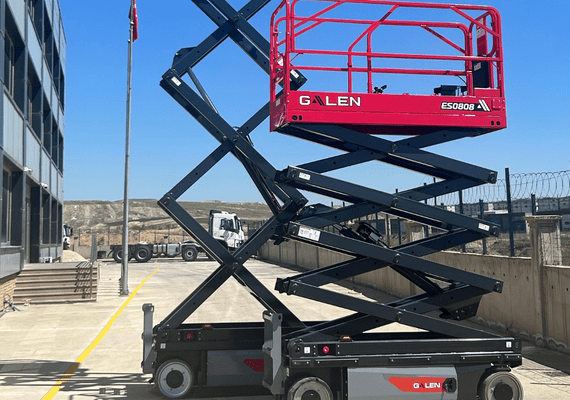 Electric warehouse scissor lift operating in narrow warehouse aisles